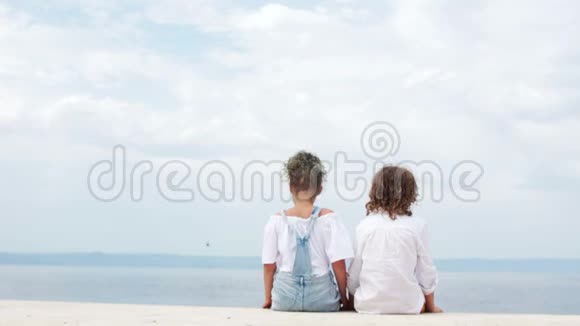 可爱的男孩和女孩坐在海滨拥抱情人节暑假青少年初恋视频的预览图