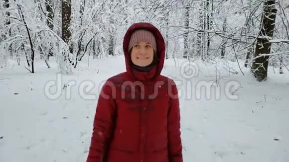 快乐的女人在冬天的森林里触摸树枝享受大自然散步视频的预览图