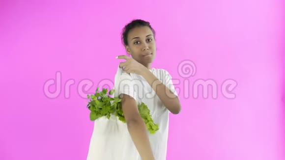 女人手里拿着粉红色背景的蔬菜包视频的预览图
