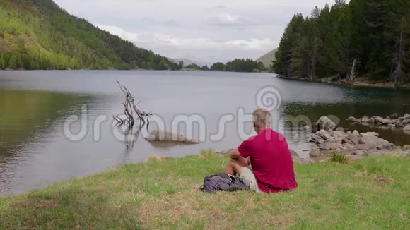 游客坐在湖边用手机拍照视频的预览图