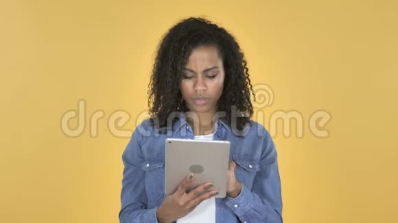 非洲女孩在黄色背景下使用平板电脑休克视频的预览图