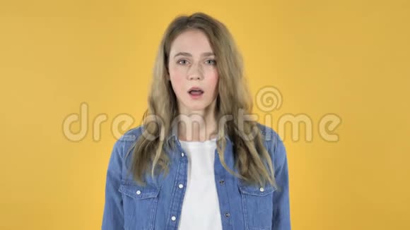 黄色背景下年轻漂亮女孩的失败与问题视频的预览图