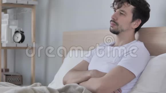 坐在床上放松的年轻人思考视频的预览图
