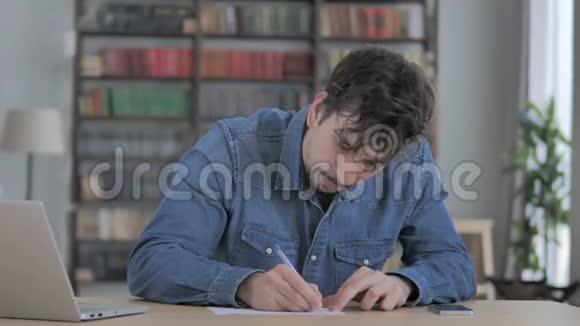 文书工作年轻人在办公桌前写作视频的预览图