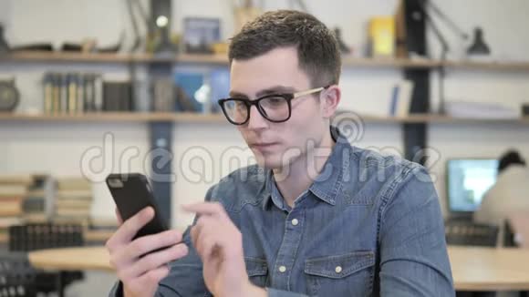 眼镜中的创意青年在电话交谈和讨论工作视频的预览图
