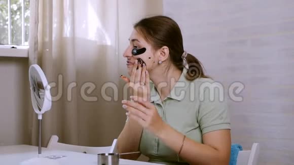 美颜护肤女人在脸上涂眼底补丁洗面膜使用天然咖啡面罩面部护理视频的预览图