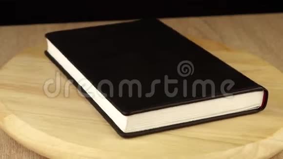 黑色笔记本在木制平台上旋转360度视频的预览图