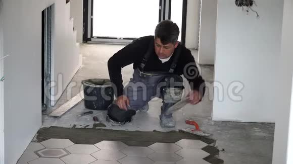 在地板上铺设六边形瓷砖向下按压和调节视频的预览图