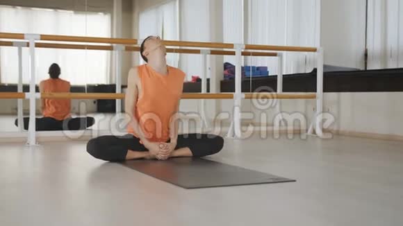 做阿萨纳阿什塔瓦克拉萨纳的年轻人手站立姿势瑜伽大师在城市工作室的黑色垫子上锻炼一个家伙视频的预览图