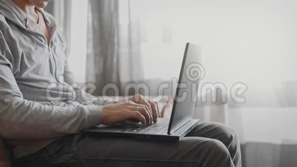 男人坐在沙发上用笔记本电脑视频的预览图