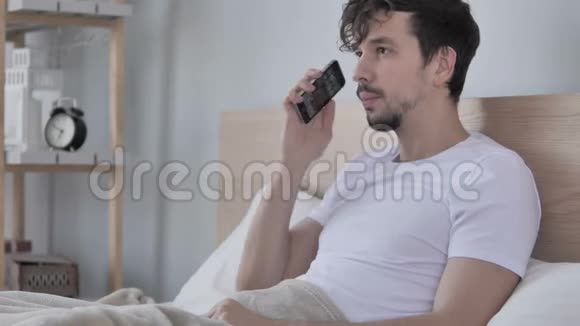 躺在床上的男人在电话里聊天视频的预览图