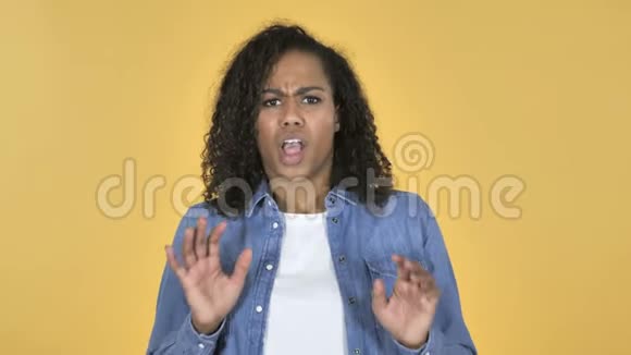 黄色背景下的非洲女孩困惑和恐惧问题视频的预览图