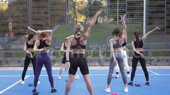 在公园健身运动中不知名的年轻运动女性在背后紧握双手视频的预览图