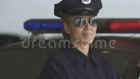 戴着帽子和太阳镜的友好巡逻妇女对着相机微笑法律保护视频的预览图