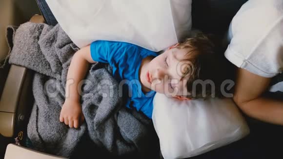 在长时间的飞机飞行中一个睡在舒适的白色枕头上的46岁白种人男孩的俯视镜头视频的预览图