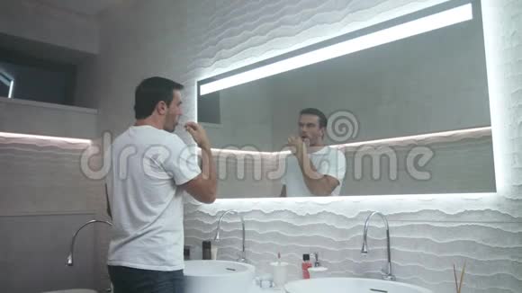 快乐男人在浴室刷牙集中男性携带牙齿视频的预览图