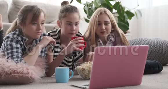 女朋友在看手提电脑的媒体内容时吃零食视频的预览图