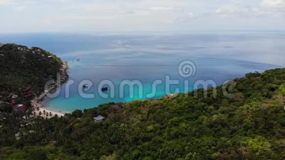 热带岛屿的风力涡轮机白色风力涡轮机位于科陶的潜水员度假胜地对抗蓝色的海洋和多云的天空视频的预览图