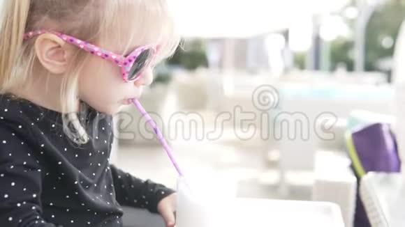 戴墨镜的小女孩喝奶昔视频的预览图