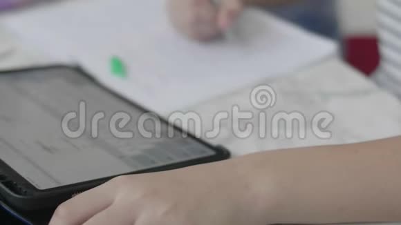 关闭男孩的手做家庭作业使用平板电脑查找信息视频的预览图