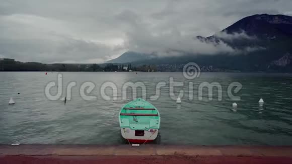 雨天雾山背景下孤独的薄荷船停泊在安纳西湖的长廊上视频的预览图