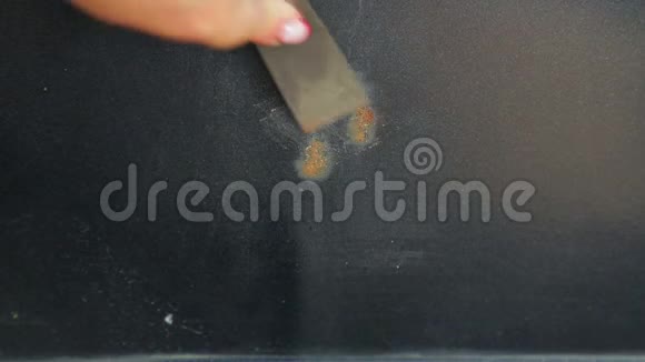 一只女手正在用刮刀清洗车体上的铁锈时光飞逝视频的预览图
