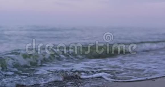 一个小波浪的镜头慢慢地撞击着沙子被拉回视频的预览图