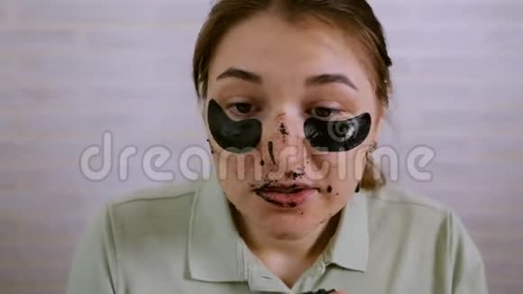 镜子附近的女孩在脸上做整容手术女孩把韩国化妆品放在她下面的区域视频的预览图