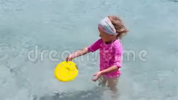 热带假期玩飞盘的小可爱女孩孩子们在浅水里玩沙滩玩具视频的预览图