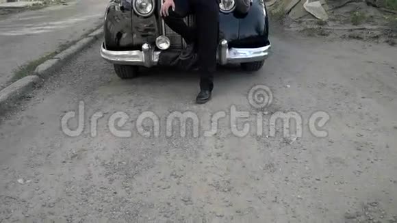 一个穿着20年代西装的家伙坐在一辆旧车上视频的预览图