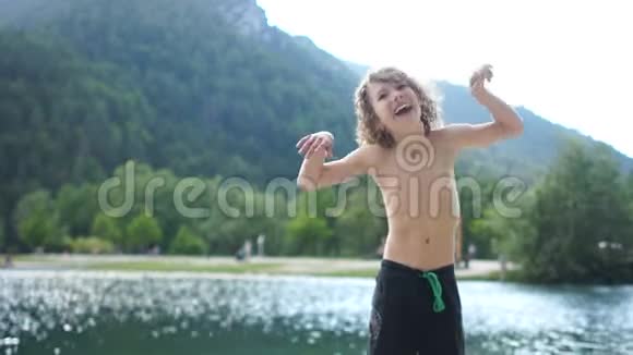 暑假期间快乐的孩子在一个山湖附近可爱的小男孩玩着玩着玩着跳舞视频的预览图