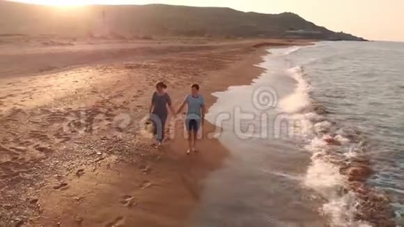 年轻夫妇在海滩上散步视频的预览图