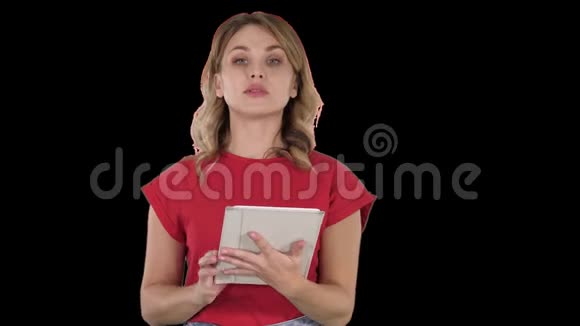 身穿红色T恤的女士手里拿着一块平板电脑严肃的脸对着镜头阿尔法频道视频的预览图