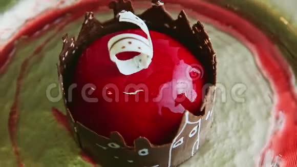 红色釉面和巧克力城堡装饰在金色盘子上的最新甜点视频的预览图
