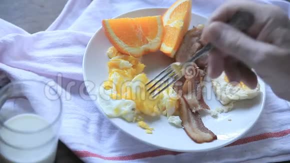 男人吃鸡蛋和培根早餐视频的预览图