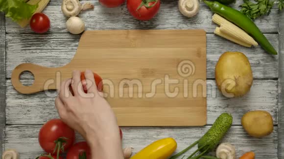 男手在木板上纺红番茄视频的预览图