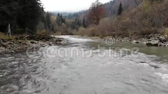 无人机在森林中沿着山河向丘陵射击视频的预览图