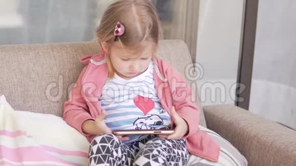 一个漂亮的小女孩在看手机上的卡通片视频的预览图