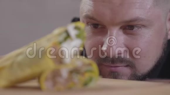 美味的沙瓦玛酱汁躺在木板上特写一个饥肠辘辘的人看着沙尔玛的脸视频的预览图