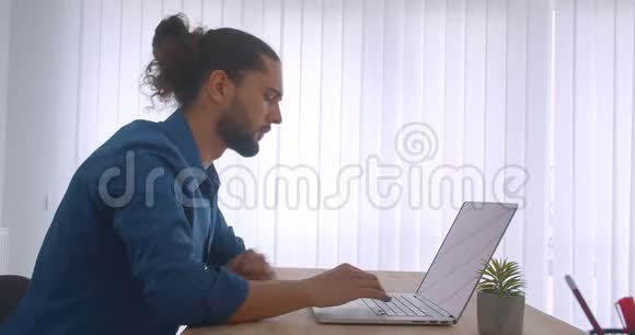 个人资料拍摄的进步商人与马尾工作与笔记本电脑在轻办公室视频的预览图