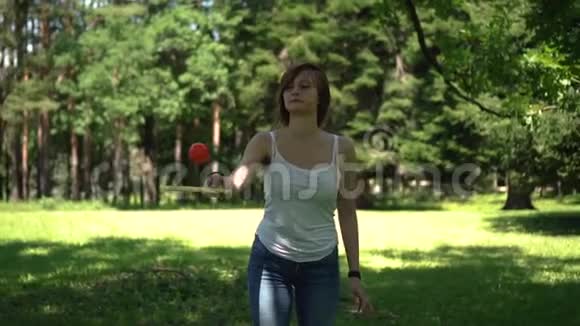 女孩在公园里拍球拍视频的预览图