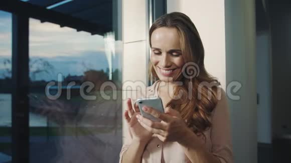 放松的女人在手机上得到有趣的信息快乐的女人用手机聊天视频的预览图