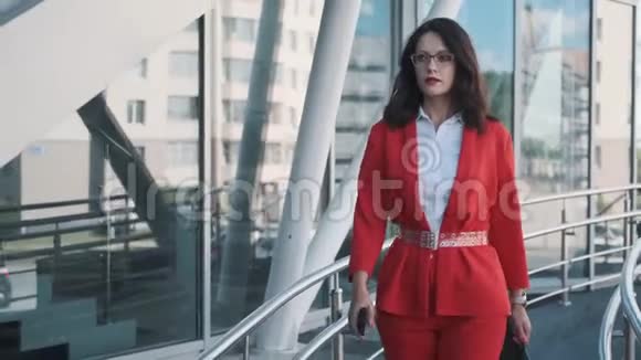 自信的商务女性穿着正式的西装走在现代商务中心的背景下视频的预览图