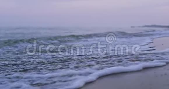 一个泡沫波撞击沙子的近景4k视频的预览图