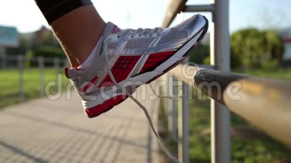 运动女士脚踩金属扶手系鞋带跑步视频的预览图