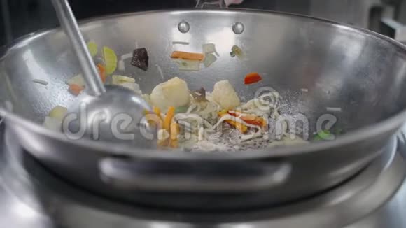 厨师在热锅里慢吞吞地煮蔬菜和鱼在热锅里搅拌亚洲面条视频的预览图