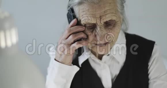 奶奶在室内用手机说话视频的预览图