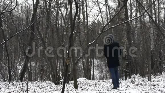 孤独的人在冬天的森林里走开视频的预览图