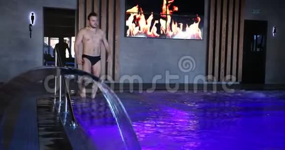 一个男人走进一家昂贵酒店的豪华游泳池慢动作方案视频的预览图