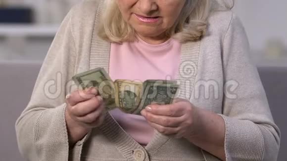 令人不安的老年妇女数着美元钞票退休金低视频的预览图